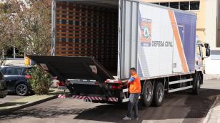 Caminhão da Defesa Civil recebendo a carga de álcool